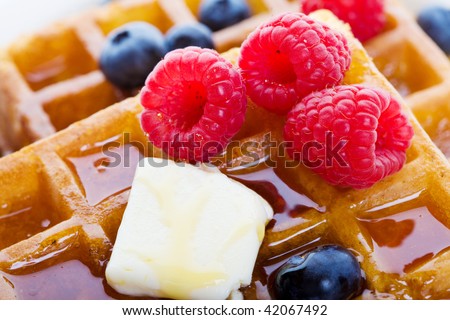 Closeup of waffles with mixed fruit and maple syrup
