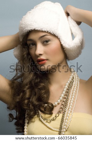 beautiful model with long hair and hat and pearls posing fashion in studio