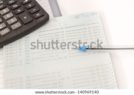 Papers on financial figures with calculator and pen.