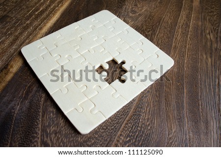 Wooden Puzzle with missing piece on a table focus pointed at the puzzle using rule of third (RO3) and shallow DOF