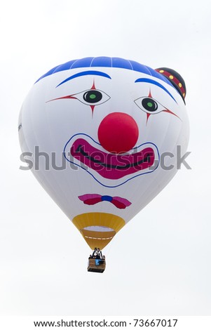 PUTRAJAYA, MALAYSIA-MAR 19:Clown face balloon from Belgium in flight at 3rd Putrajaya International Hot Air Balloon Fiesta Mar 19, 2011 in Putrajaya.More than 300,000 people visit this yearly event