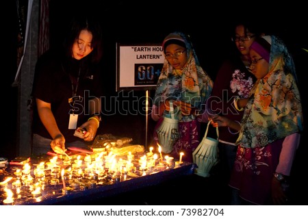 KUALA LUMPUR, MALAYSIA-MAR 26:Participant of Earth Hour Campaign wait to light-up the lantern on Mar 26, 2011 in Kuala Lumpur.More than 4,000 cities in 131 countries celebrate Earth Hour