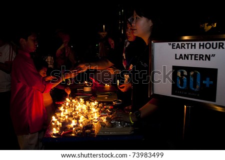 KUALA LUMPUR, MALAYSIA-MAR 26:Volunteer of Earth Hour Campaign distribute candle and lantern on Mar 26, 2011 in Kuala Lumpur.More than 4,000 cities in 131 countries celebrate Earth Hour