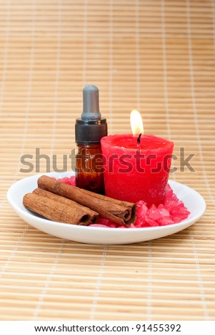 Aromatherapy Candle with Cinnamon Stick on Bamboo Mat for relaxation spa and wellness concept