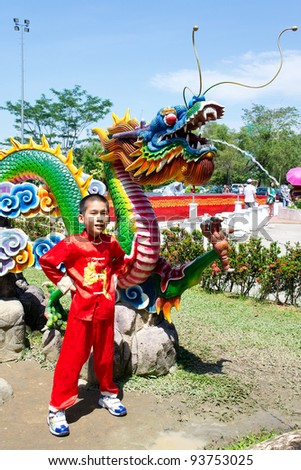KUALA LUMPUR-JAN 24:Ng Wen Song (10 years old) posed next to a Water Dragon Statue at Thean Hou Temple during Chinese New Year of the Dragon celebrations on January 24, 2012 in Kuala Lumpur, Malaysia.