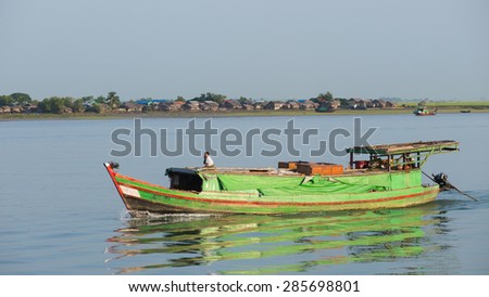 Sittwe, Rakhine State, Myanmar - October 16, 2014: Cargo vessel travelling down the Kaladan River on its way to Sittwe, the capital of the Rakhine State in Myanmar.