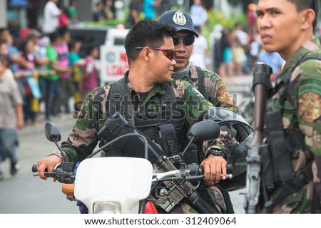 General Santos City, The Philippines - September 1, 2015: Armed police guarding the parade of the 17th Annual Gensan Tuna Festival to celebrate the  most important industry of city.