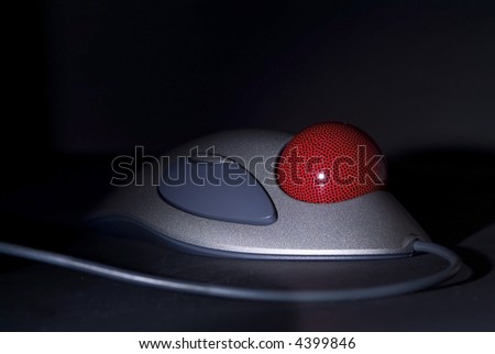 Trackball on black background. Shallow depth of field with parts of the device disappearing into the dark.