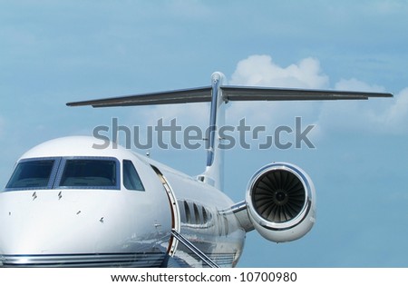 White, two-engine executive jet aircraft on the ground with door open.