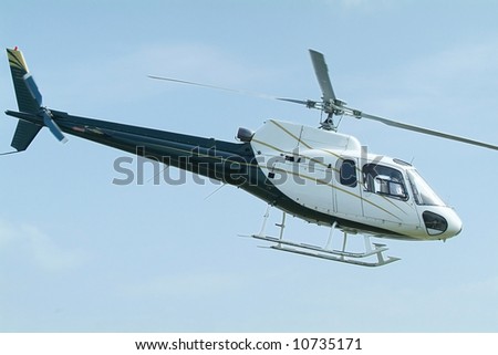 Small, blue and white, passenger helicopter mid-air