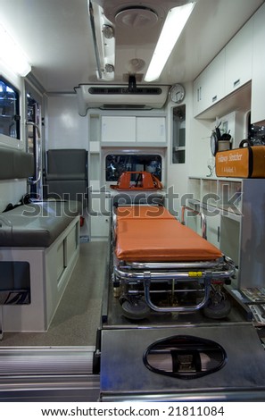 Interior of ambulance vehicle with stretcher and emergency equipment.