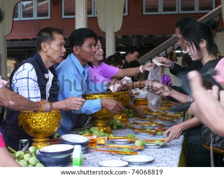 NAKHON CHAISI - MARCH 19: Volunteers selling lotus flowers and incense sticks to visitors to the Tattoo Festival at Wat Bang Phra on March 19, 2011 in Nakhon Chaisi, Thailand.