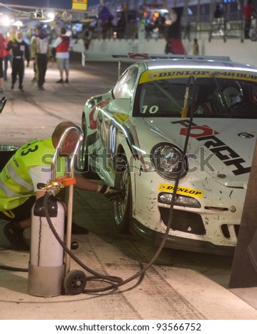 DUBAI - JANUARY 13: Pit stop at night for car 10, a Porsche 997 GT3 Cup during the 2012 Dunlop 24 Hour Race at Dubai Autodrome on January 13, 2012.