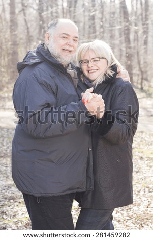 Happy Elderly Senior Romantic Couple holding hands in nature, Old people portrait outdoor winter autumn season.