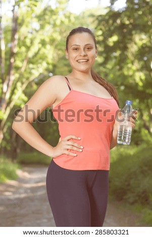 Fitness Smiling Healthy Young Woman with bottle of water outdoor,