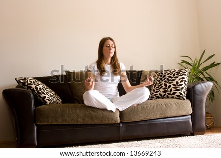 Young woman practice yoga in apartment on bed.