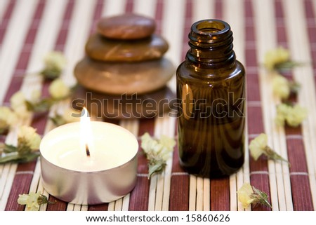 Zen like balanced stones, dried flower, essential oil and candle on bamboo background.