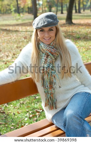 Beautiful young woman sitting on bench in the park.