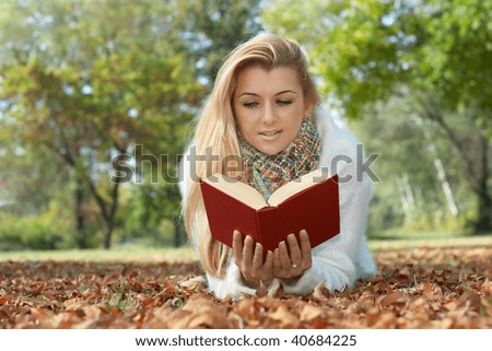 Beautiful student reading book in the park.
