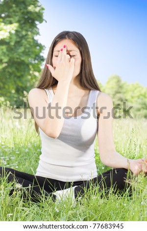 Woman doing breathing exercise yoga pose outdoors.