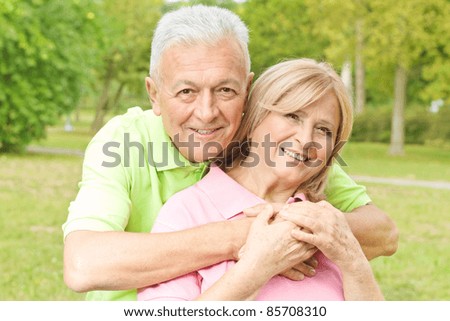 Closeup portrait of happy elderly man embracing mature woman.