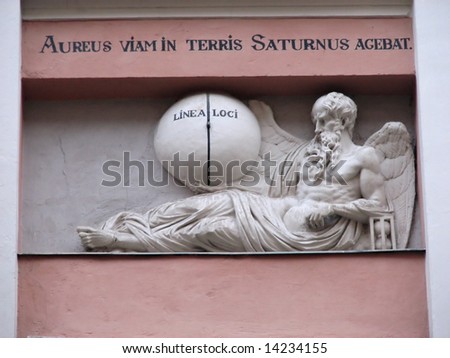 bas-relief of Saturn on  facade of the ancient building with latin phrase