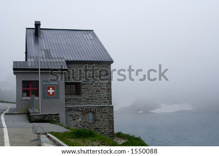 The Swiss-Italian border control pass, the famous Saint-Bernard mountain. foggy behind the house