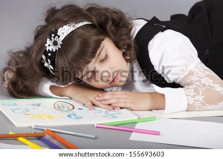 cute girl sleep with her colorful drawing for school, tired