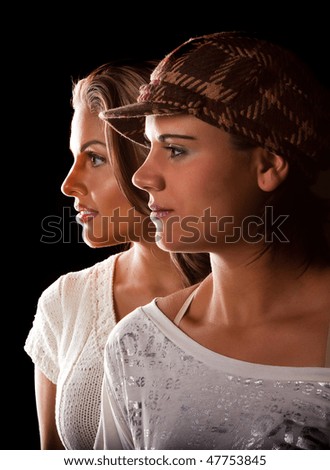 Two beautiful brunettes in black background. Shallow depth of field