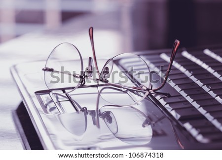 Glasses on the laptop keyboard. Concept search and research on Internet websites.