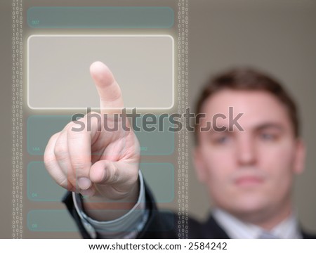 Young businessman pushing a button area on a translucent, hi-tech screen. Shallow depth of field.