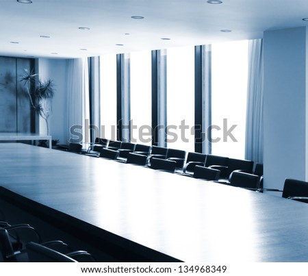 Boardroom conference room table brightly lit in blue colors
