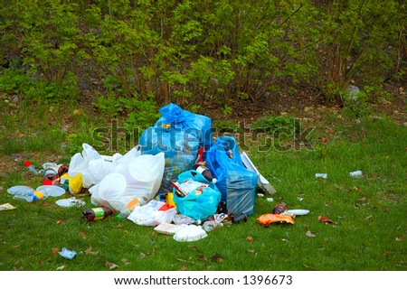 Pile of garbage on green grass in the nature environment problems