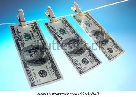 Hundred dollar bills drying on a clothes line isolated on blue sky background Money laundering concept