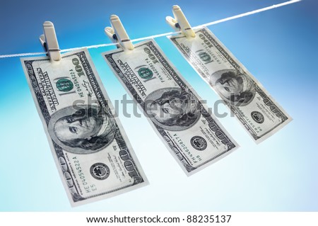 Hundred dollar bills drying on a clothes line isolated on blue sky background Money laundering concept