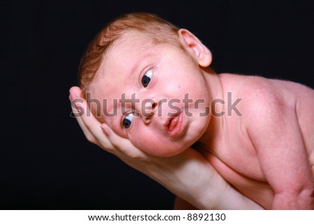 Newborn baby boy with adorable face expression.