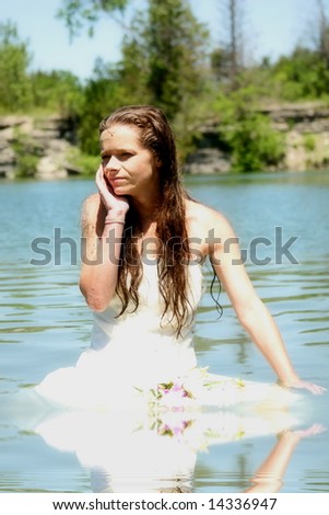 Beautiful woman floating in the water  with her wedding dress.