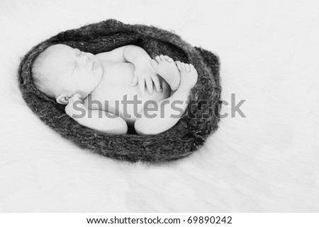 Newborn baby girl in a cocoon crochet blanket, sleeping.