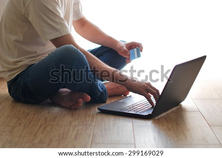 Man shopping online using laptop at home