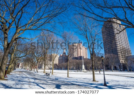 New Haven Green with snow and blue sky: a park in downtown New Haven, CT used for public events and bordered by Yale University.