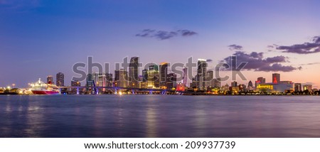 Miami city skyline panorama at twilight with urban skyscrapers and bridge