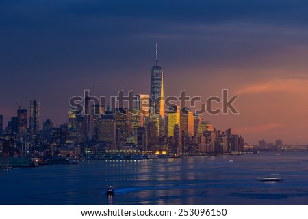 New York City with skyscrapers illuminated over Hudson River panorama, including the One World Trade Center