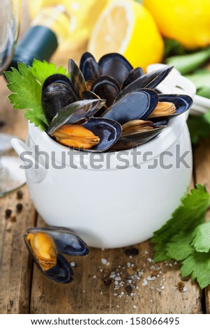 Mussels cooked with white wine sauce in a white pot
