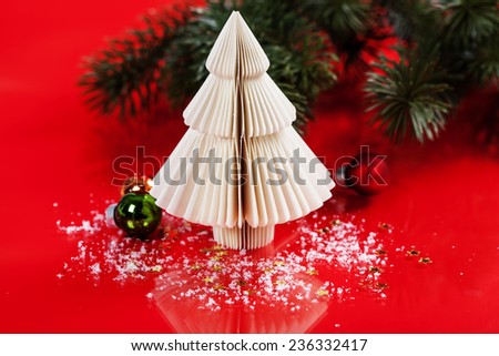 Christmas tree made of paper and decorations on red background