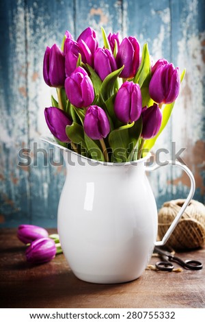 Purple Tulips, garden tools and easter eggs on a wooden surface. Studio photography