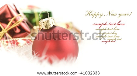 Christmas balls and gift boxes on white feather (with sample text)