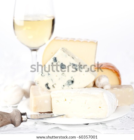 White wine and Various types of cheese on a plate