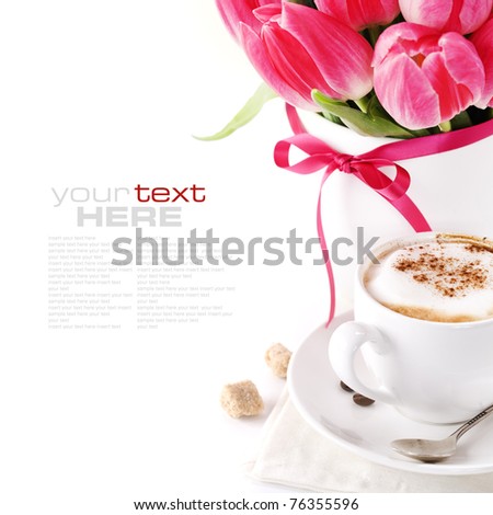 white cup of coffee with pink tulips in a vase