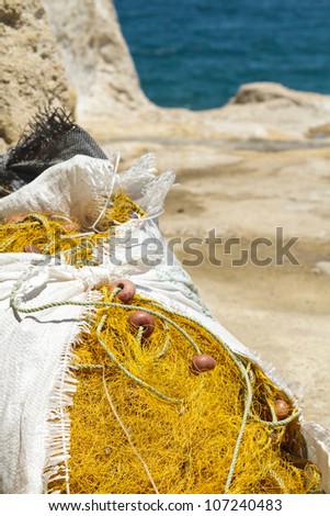 A pile of fishing nets stored in a nylon sack by the sea