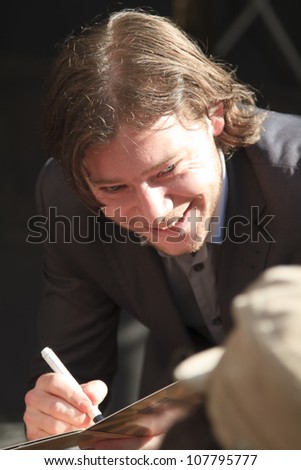 DORDRECHT, NETHERLANDS - JULY 15: Martijn Smit smiling and signing a cd cover for a fan after the performance for The Jig at the Big Rivers Festival on Sunday 15 July 2012 in Dordrecht.